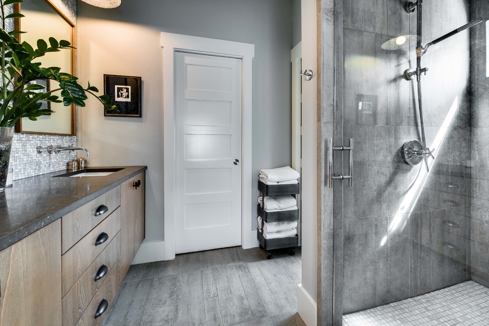 На фото: главная ванная комната среднего размера в стиле модернизм с угловым душем, унитазом-моноблоком, серой плиткой, цементной плиткой, серыми стенами, полом из керамической плитки и столешницей из известняка