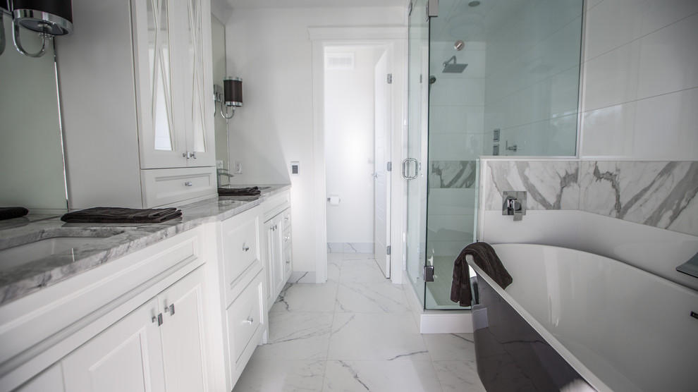 Large traditional ensuite bathroom in Other with a submerged sink, shaker cabinets, white cabinets, granite worktops, a freestanding bath, a corner shower, a one-piece toilet, white tiles, porcelain tiles, white walls and porcelain flooring.