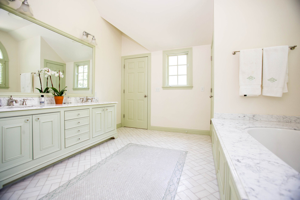 Aménagement d'une salle de bain principale classique avec un lavabo posé, un placard avec porte à panneau surélevé, des portes de placard blanches, un plan de toilette en marbre, une baignoire posée, une douche d'angle, des carreaux de céramique, un mur blanc et un sol en carrelage de céramique.