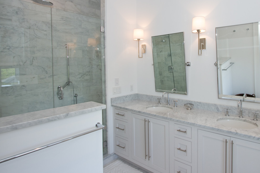 Photo of a medium sized beach style shower room bathroom in Miami with beaded cabinets, white cabinets, an alcove bath, a shower/bath combination, a two-piece toilet, grey tiles, white tiles, stone tiles, white walls, marble flooring, a submerged sink and marble worktops.
