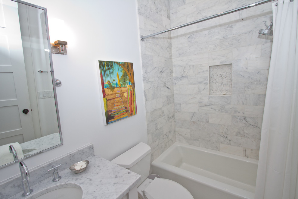 Exempel på ett mellanstort maritimt badrum med dusch, med luckor med profilerade fronter, vita skåp, ett badkar i en alkov, en dusch/badkar-kombination, en toalettstol med separat cisternkåpa, grå kakel, vit kakel, stenkakel, röda väggar, ett undermonterad handfat och marmorbänkskiva