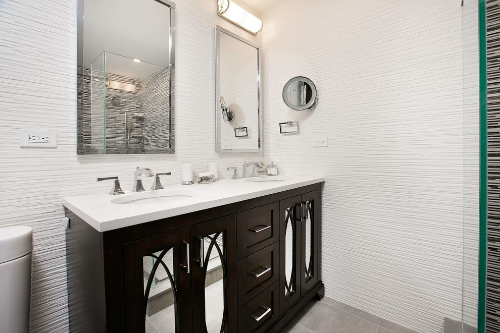 ニューヨークにある中くらいなトランジショナルスタイルのおしゃれな浴室 (シェーカースタイル扉のキャビネット、濃色木目調キャビネット、コーナー設置型シャワー、黒いタイル、グレーのタイル、白い壁、セラミックタイルの床、アンダーカウンター洗面器、珪岩の洗面台、グレーの床、開き戸のシャワー) の写真