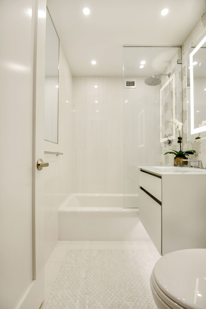 Стильный дизайн: маленькая ванная комната в стиле неоклассика (современная классика) с стеклянными фасадами, серыми фасадами, ванной в нише, душем над ванной, унитазом-моноблоком, серой плиткой, керамической плиткой, серыми стенами, полом из керамической плитки, монолитной раковиной, стеклянной столешницей, серым полом, душем с распашными дверями и белой столешницей для на участке и в саду - последний тренд