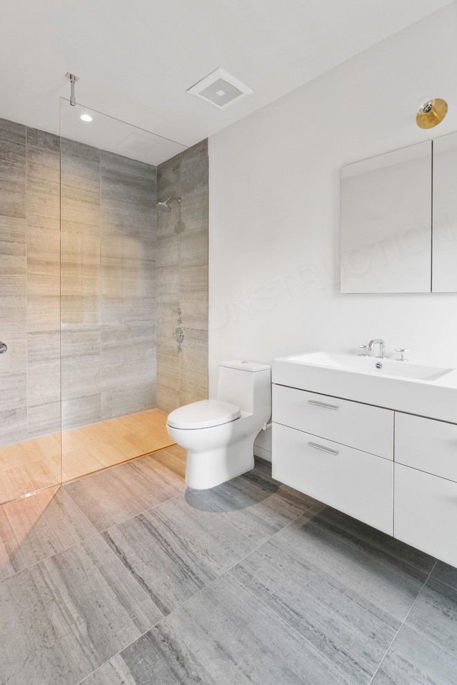 На фото: главная ванная комната среднего размера в стиле модернизм с плоскими фасадами, белыми фасадами, душем без бортиков, унитазом-моноблоком, серой плиткой, керамогранитной плиткой, белыми стенами, полом из керамогранита, монолитной раковиной, столешницей из ламината, серым полом и открытым душем