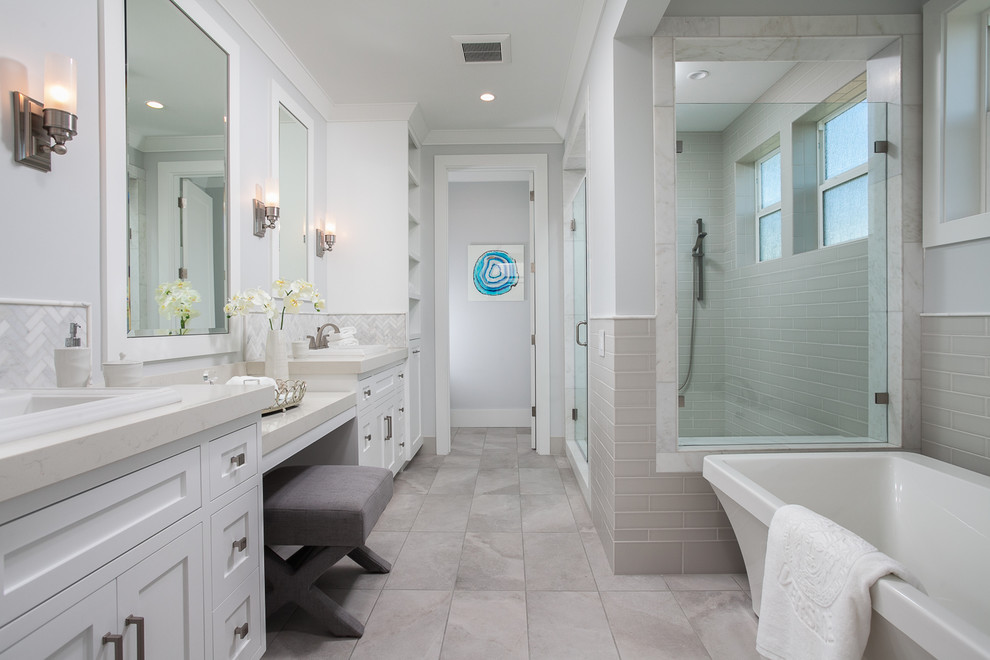 Farmhouse gray tile gray floor freestanding bathtub photo in Orange County with shaker cabinets, white cabinets, gray walls, a drop-in sink and white countertops