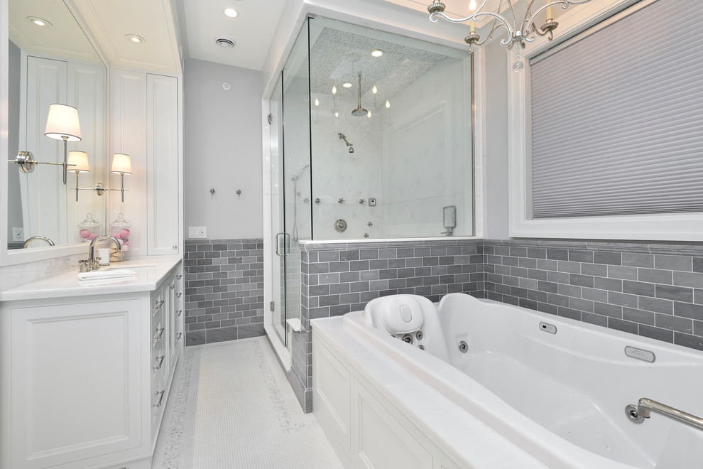 Photo of a traditional bathroom in Chicago with a submerged sink, recessed-panel cabinets, white cabinets, a built-in bath, a corner shower, grey tiles, metro tiles, grey walls and mosaic tile flooring.