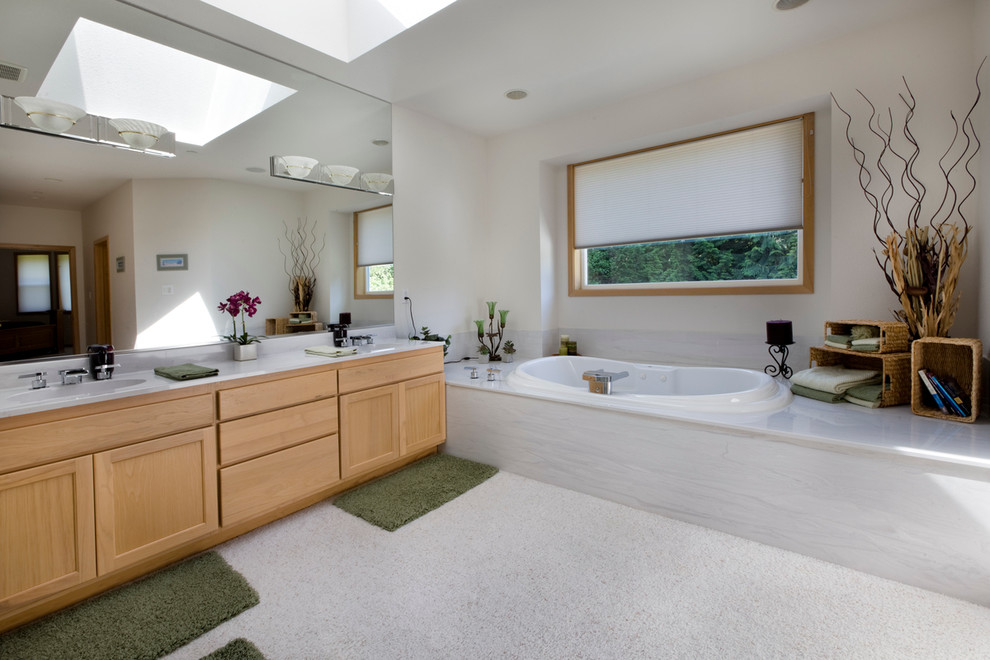 Réalisation d'une salle de bain design en bois brun avec un placard à porte shaker, une baignoire posée et un carrelage gris.