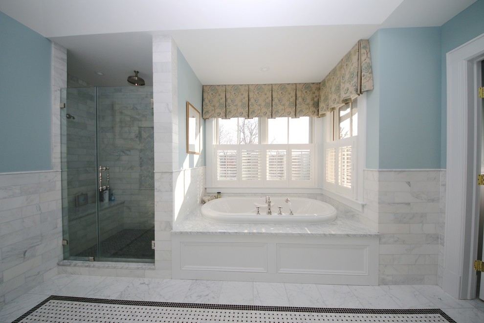 Foto på ett stort vintage en-suite badrum, med luckor med infälld panel, vita skåp, ett badkar i en alkov, en dusch i en alkov, en toalettstol med separat cisternkåpa, grå kakel, stenkakel, blå väggar, marmorgolv, ett undermonterad handfat och marmorbänkskiva