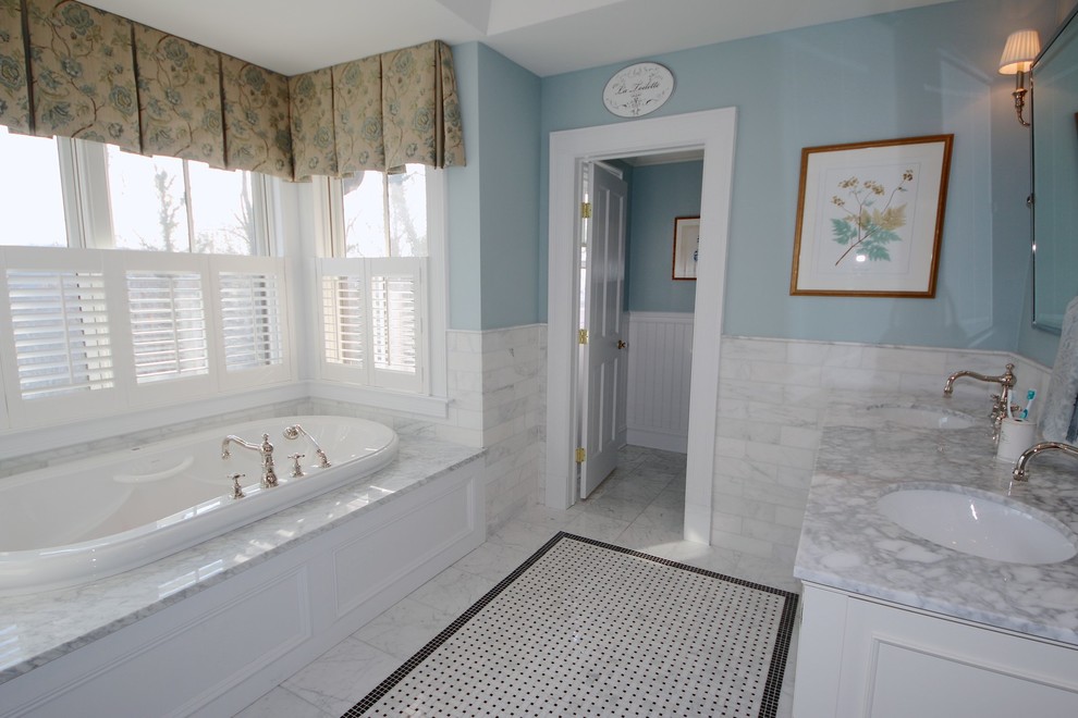 На фото: большая главная ванная комната в викторианском стиле с фасадами с утопленной филенкой, белыми фасадами, ванной в нише, душем в нише, раздельным унитазом, серой плиткой, каменной плиткой, синими стенами, мраморным полом, врезной раковиной и мраморной столешницей