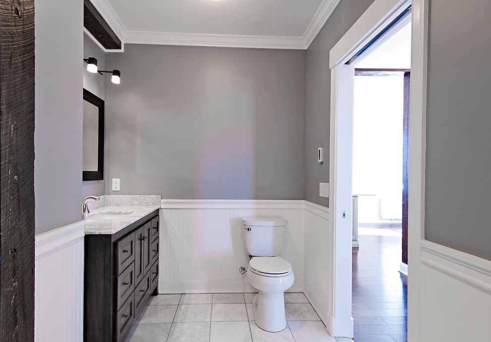 Bathroom - mid-sized transitional master beige tile and stone tile ceramic tile bathroom idea in Portland Maine with an undermount sink, recessed-panel cabinets, dark wood cabinets, quartz countertops, a two-piece toilet and gray walls