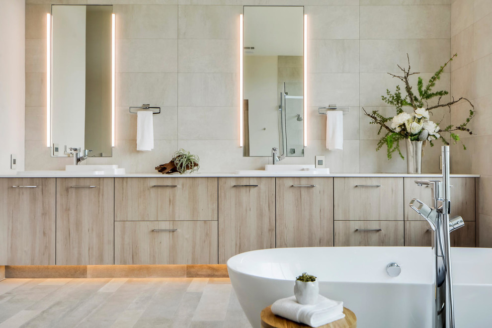 Идея дизайна: главная ванная комната в современном стиле с плоскими фасадами, светлыми деревянными фасадами, отдельно стоящей ванной и бежевой плиткой