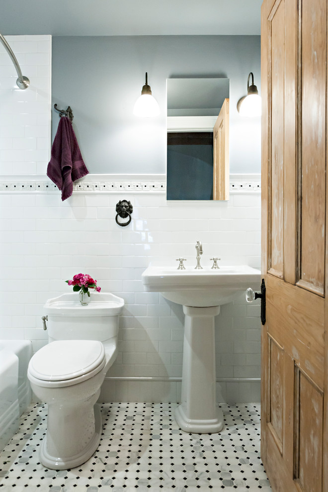 This is an example of a small victorian bathroom in New York with an alcove bath, a shower/bath combination, a one-piece toilet, white tiles, metro tiles, grey walls, marble flooring, a pedestal sink and a shower curtain.