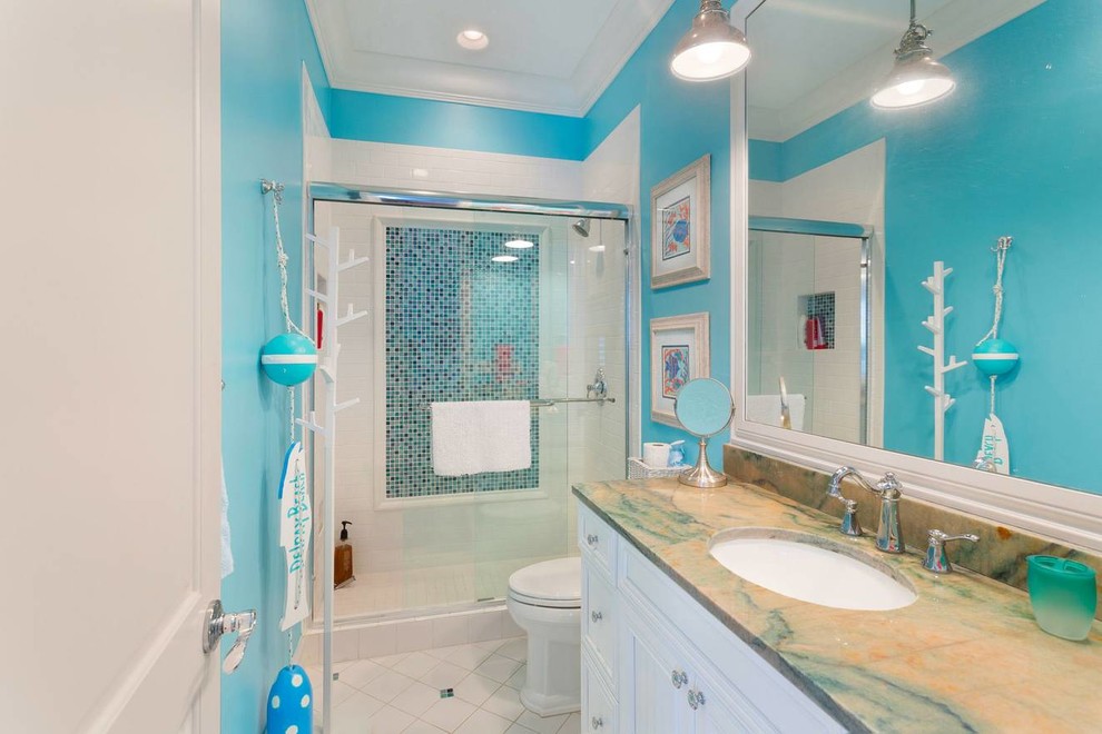 Свежая идея для дизайна: главная ванная комната среднего размера в морском стиле с фасадами с утопленной филенкой, белыми фасадами, душем в нише, унитазом-моноблоком, белой плиткой, плиткой кабанчик, синими стенами, полом из керамической плитки, врезной раковиной, мраморной столешницей, белым полом, душем с раздвижными дверями и разноцветной столешницей - отличное фото интерьера