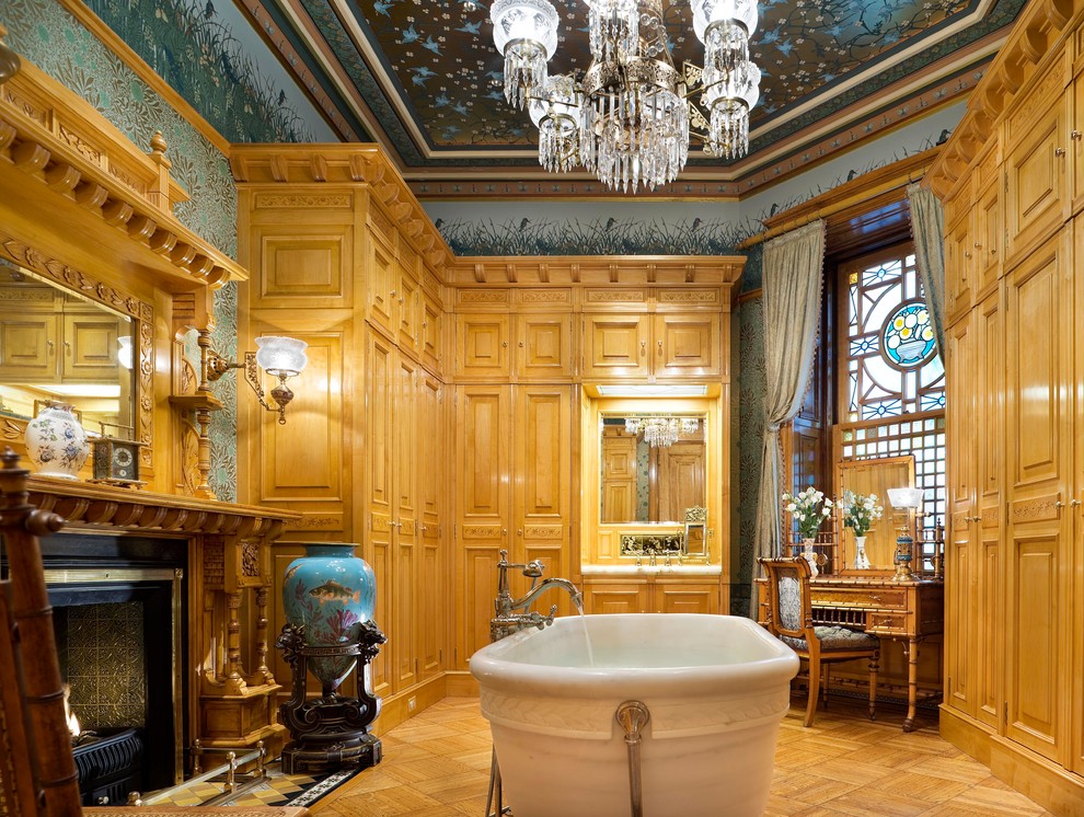 На фото: большая главная ванная комната в классическом стиле с фасадами с выступающей филенкой, светлыми деревянными фасадами, ванной на ножках, разноцветными стенами и светлым паркетным полом с