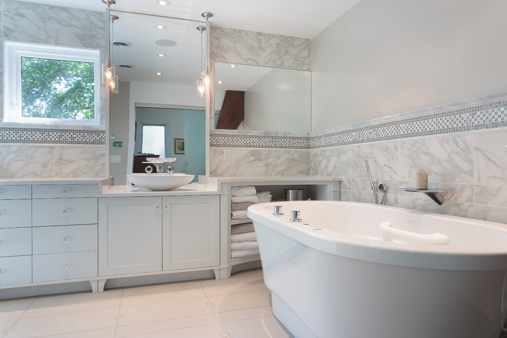 Large traditional ensuite bathroom in Other with shaker cabinets, grey cabinets, a freestanding bath, grey tiles, white tiles, mosaic tiles, marble worktops, a corner shower, a one-piece toilet, grey walls, porcelain flooring, a vessel sink, white floors and a hinged door.