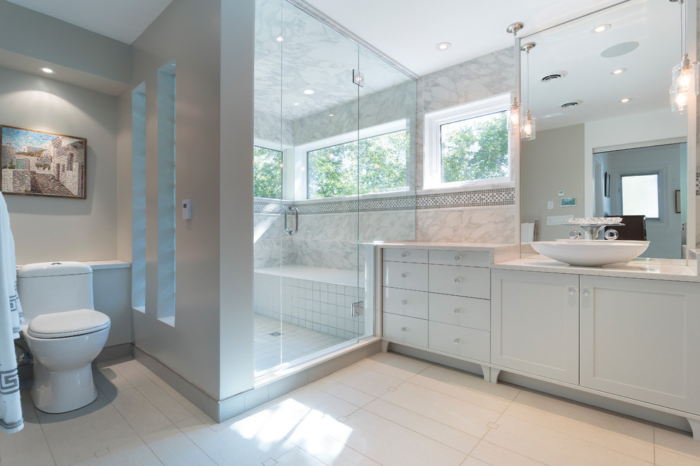 Свежая идея для дизайна: большая главная ванная комната в классическом стиле с фасадами в стиле шейкер, белыми фасадами, угловым душем, унитазом-моноблоком, серой плиткой, белой плиткой, плиткой мозаикой, серыми стенами, полом из керамогранита, настольной раковиной, мраморной столешницей, белым полом, душем с распашными дверями и отдельно стоящей ванной - отличное фото интерьера