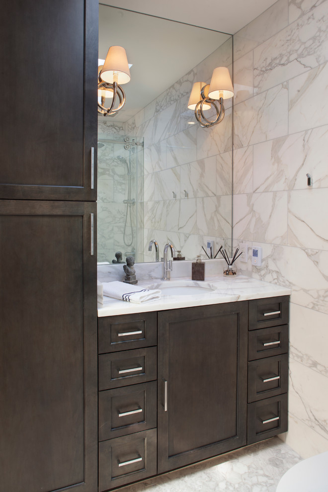 Photo of a large traditional ensuite bathroom in San Francisco with recessed-panel cabinets, dark wood cabinets, a wall mounted toilet, grey tiles, white tiles, stone tiles, white walls, marble flooring, a submerged sink and marble worktops.