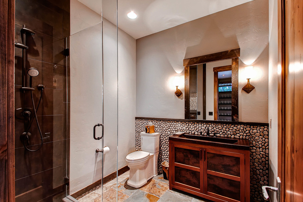 Inspiration för rustika badrum, med ett integrerad handfat, en hörndusch, en toalettstol med separat cisternkåpa och kakel i småsten