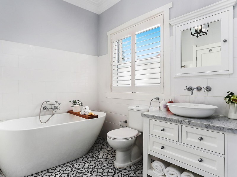 This is an example of a medium sized traditional ensuite bathroom in Sydney with shaker cabinets, white cabinets, a freestanding bath, a walk-in shower, a one-piece toilet, black and white tiles, grey walls, ceramic flooring, a console sink and marble worktops.