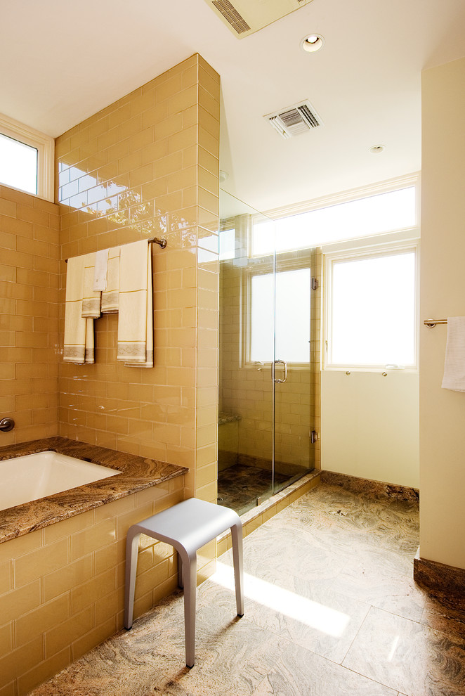 Example of a trendy beige tile and glass tile alcove shower design in New Orleans with an undermount tub