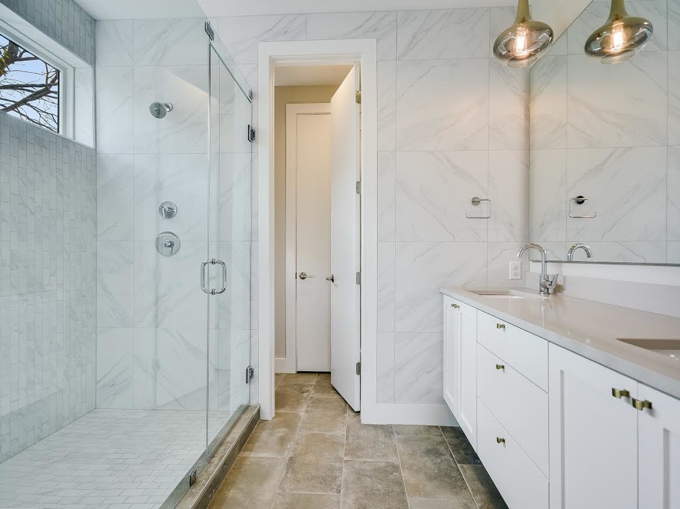 Inspiration pour une salle de bain principale design de taille moyenne avec un placard à porte shaker, des portes de placard blanches, une douche d'angle, un carrelage gris, un carrelage blanc, un carrelage de pierre, un sol en travertin, un lavabo encastré, un plan de toilette en quartz modifié, une baignoire d'angle, WC séparés, un mur blanc, un sol marron et une cabine de douche à porte battante.