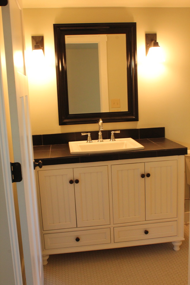 Immagine di una stanza da bagno american style con ante in stile shaker, ante bianche, top piastrellato, piastrelle nere, piastrelle in ceramica e pavimento in gres porcellanato