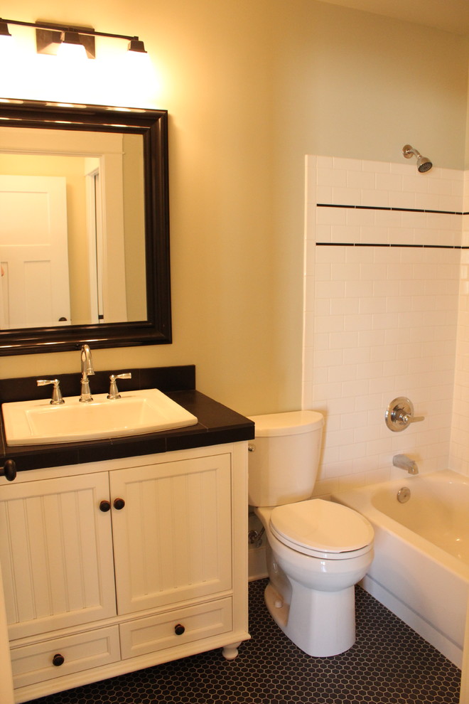 Immagine di una stanza da bagno stile americano con ante in stile shaker, ante bianche, top piastrellato, piastrelle nere, piastrelle in ceramica e pavimento in gres porcellanato