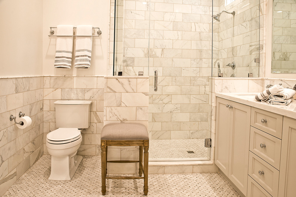 Exempel på ett mellanstort klassiskt en-suite badrum, med ett nedsänkt handfat, skåp i shakerstil, vita skåp, marmorbänkskiva, ett hörnbadkar, en hörndusch, en toalettstol med hel cisternkåpa, vit kakel, keramikplattor, vita väggar och mosaikgolv