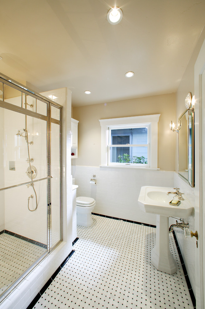 Photo of a small classic ensuite bathroom in Sacramento with raised-panel cabinets, white cabinets, an alcove shower, a one-piece toilet, white tiles, metro tiles, beige walls, marble flooring, a pedestal sink, white floors and a hinged door.