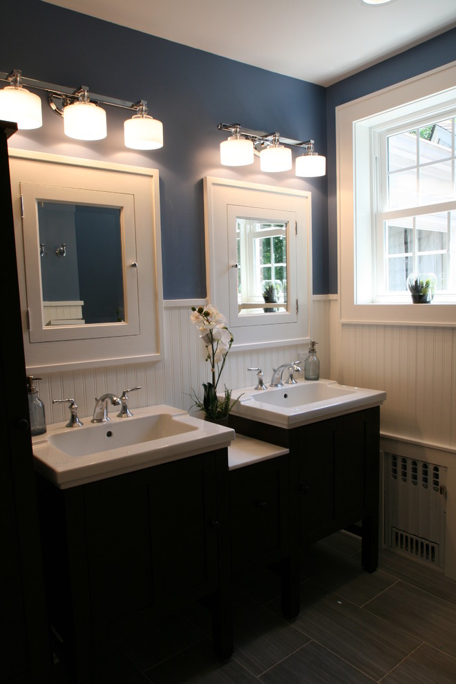 Idées déco pour une salle de bain principale craftsman de taille moyenne avec un placard à porte shaker, des portes de placard noires, une baignoire en alcôve, un combiné douche/baignoire, WC séparés, un mur bleu, un sol en carrelage de porcelaine, un lavabo encastré et un plan de toilette en surface solide.