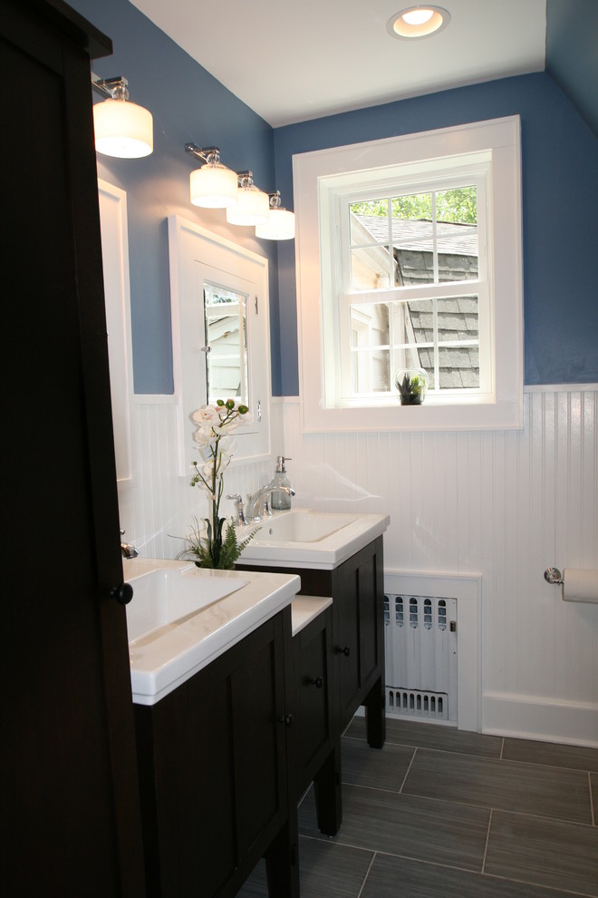 Mid-sized arts and crafts master porcelain tile bathroom photo in New York with shaker cabinets, black cabinets, a two-piece toilet, blue walls, an undermount sink and solid surface countertops