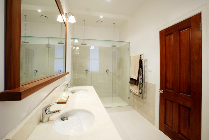 Idée de décoration pour une salle de bain tradition en bois brun de taille moyenne avec un lavabo encastré, un placard en trompe-l'oeil, un plan de toilette en marbre, une douche double, un carrelage beige, des carreaux de porcelaine, un mur blanc et un sol en carrelage de porcelaine.