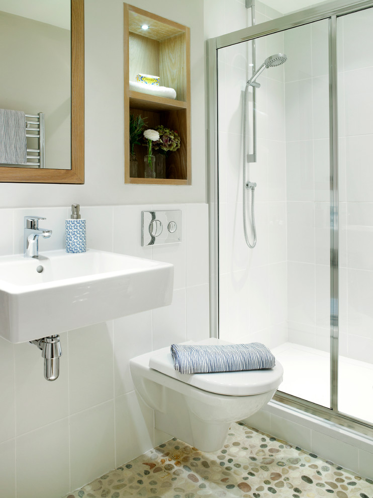 Small transitional white tile and ceramic tile pebble tile floor alcove shower photo in London with a wall-mount sink, a wall-mount toilet and white walls