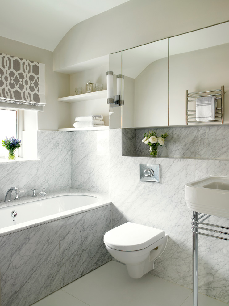Foto på ett mellanstort vintage en-suite badrum, med ett undermonterat badkar, vit kakel, stenhäll, grå väggar, klinkergolv i porslin, en vägghängd toalettstol, ett konsol handfat, kaklad bänkskiva och vitt golv