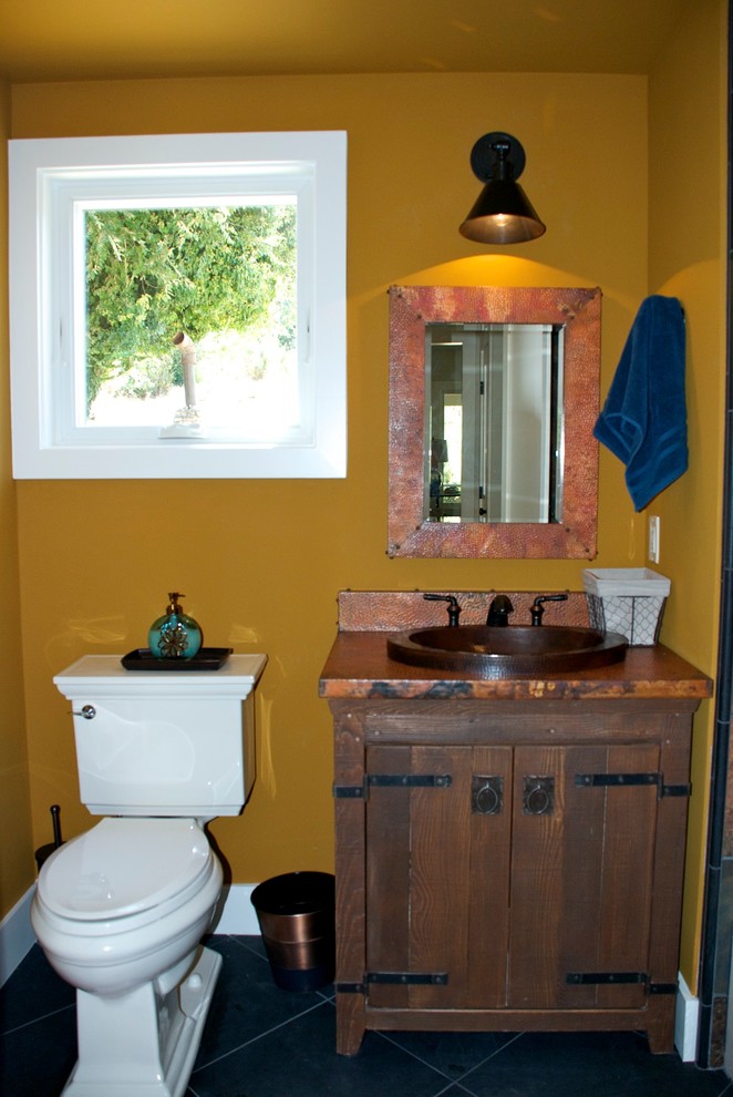 Small farmhouse shower room bathroom in San Diego with freestanding cabinets, dark wood cabinets, a built-in bath, a shower/bath combination, a two-piece toilet, brown walls, slate flooring, a built-in sink and copper worktops.