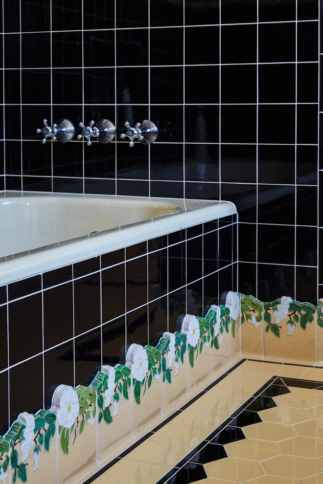 Idée de décoration pour une salle de bain principale tradition de taille moyenne avec des portes de placard blanches, une baignoire en alcôve, un carrelage noir, des carreaux de porcelaine, un mur blanc, un sol en carrelage de porcelaine, un lavabo de ferme et un plan de toilette en carrelage.