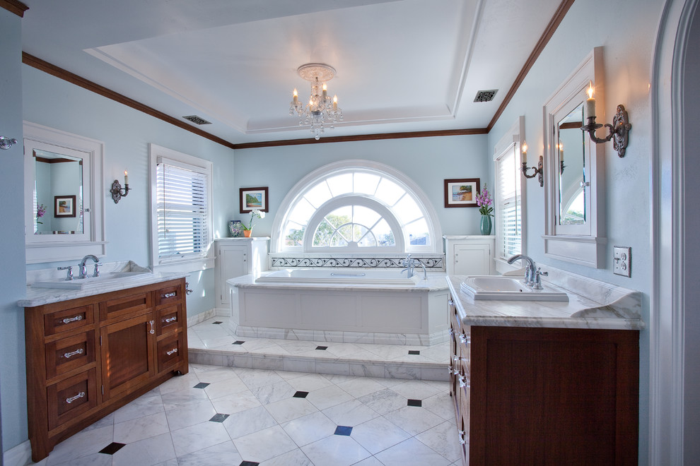 На фото: главная ванная комната в стиле фьюжн с раздельным унитазом, синими стенами, фасадами в стиле шейкер, темными деревянными фасадами, отдельно стоящей ванной, белой плиткой, плиткой из листового камня, полом из керамической плитки, накладной раковиной и мраморной столешницей с