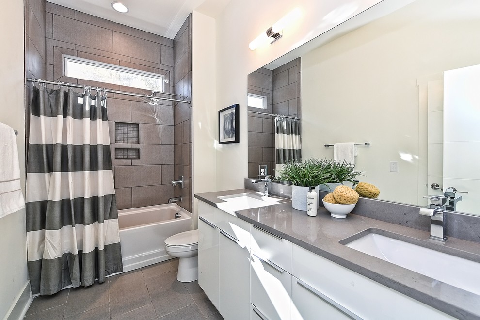 Foto de cuarto de baño clásico renovado con armarios con paneles lisos, puertas de armario blancas, bañera empotrada, combinación de ducha y bañera, baldosas y/o azulejos grises, paredes blancas, aseo y ducha, lavabo bajoencimera, suelo gris, ducha con cortina y encimeras grises