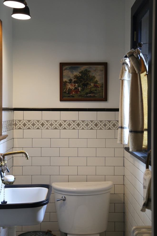 Kleines Landhaus Badezimmer mit Wandtoilette mit Spülkasten, schwarz-weißen Fliesen, Keramikfliesen, grauer Wandfarbe, Keramikboden und Wandwaschbecken in Sonstige