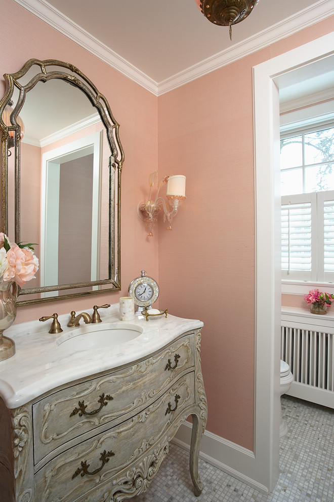 Cette image montre une salle de bain grise et rose traditionnelle avec un lavabo encastré, des portes de placard grises, un mur rose et un sol en carrelage de terre cuite.
