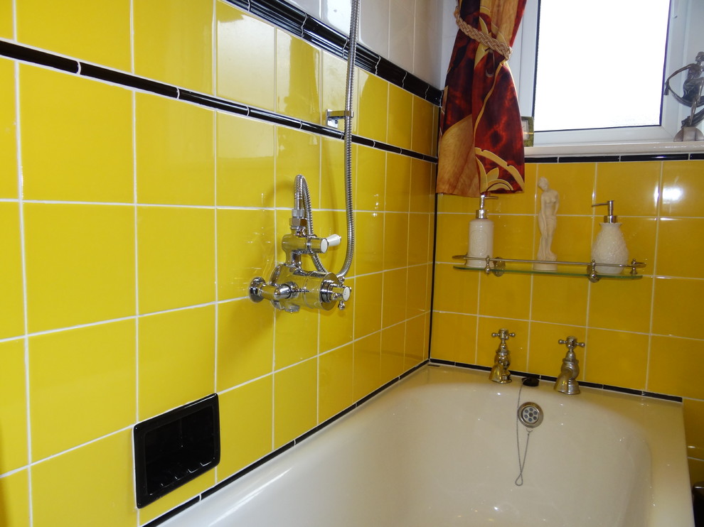 Immagine di una piccola stanza da bagno per bambini moderna con vasca da incasso, vasca/doccia, WC monopezzo, piastrelle gialle, piastrelle in ceramica, pavimento in vinile e lavabo a colonna