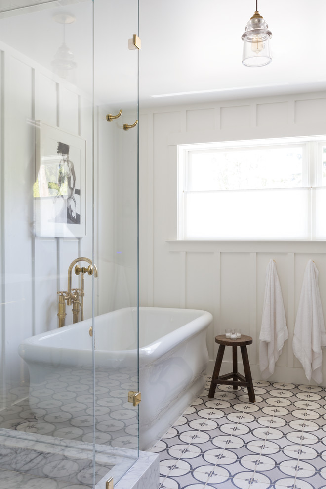 Idée de décoration pour une salle de bain principale tradition avec un placard avec porte à panneau encastré, une baignoire indépendante, des carreaux de céramique, un mur blanc, un sol en carrelage de céramique et un carrelage bleu.