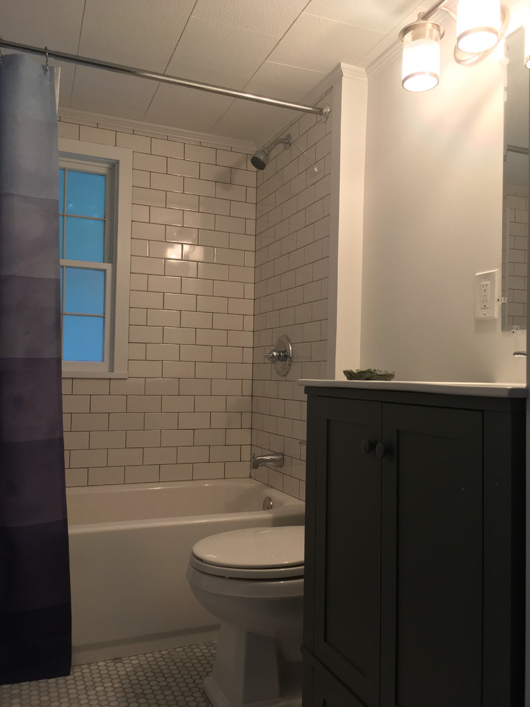 Exemple d'une petite salle de bain chic avec un placard à porte shaker, des portes de placard grises, une baignoire en alcôve, un combiné douche/baignoire, WC séparés, un carrelage blanc, un carrelage métro, un mur blanc, un sol en carrelage de terre cuite, un lavabo intégré et un plan de toilette en surface solide.
