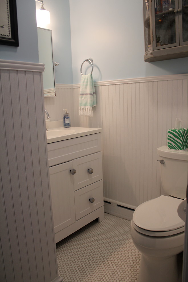 Ispirazione per una stanza da bagno costiera di medie dimensioni con ante a filo, ante bianche, WC a due pezzi, pareti blu, pavimento con piastrelle a mosaico, lavabo integrato e top in superficie solida