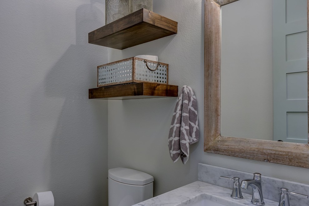 Immagine di una piccola stanza da bagno country con WC a due pezzi, pareti grigie, lavabo sottopiano e top in marmo