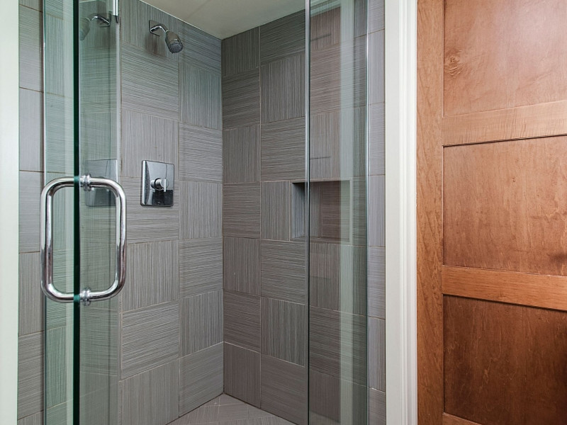 Immagine di una stanza da bagno design con doccia ad angolo, piastrelle grigie e piastrelle in gres porcellanato