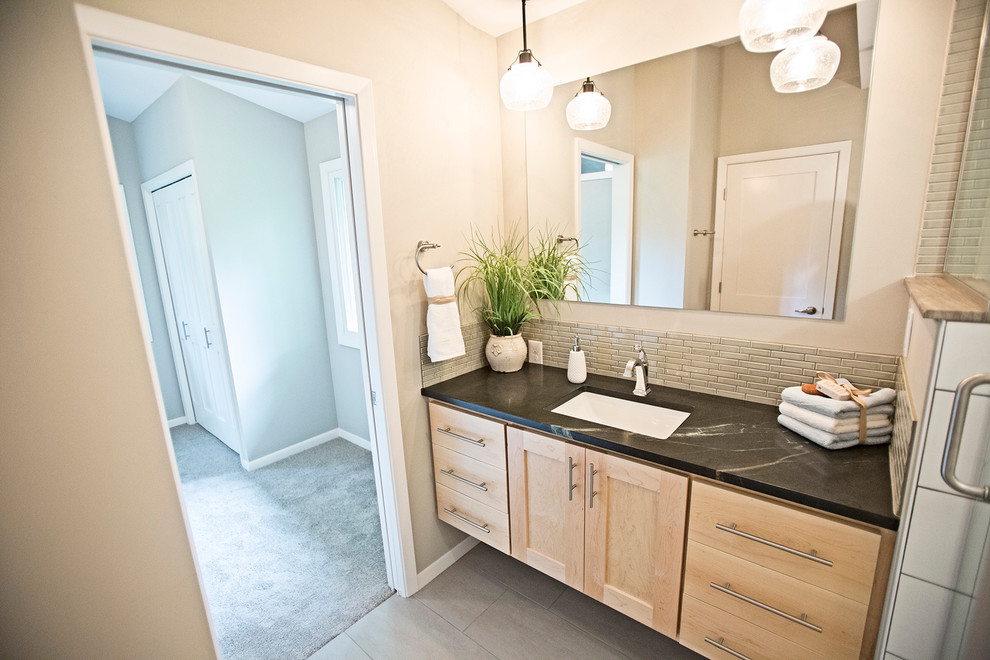 Immagine di una stanza da bagno minimal con ante in stile shaker, ante in legno chiaro e top in saponaria