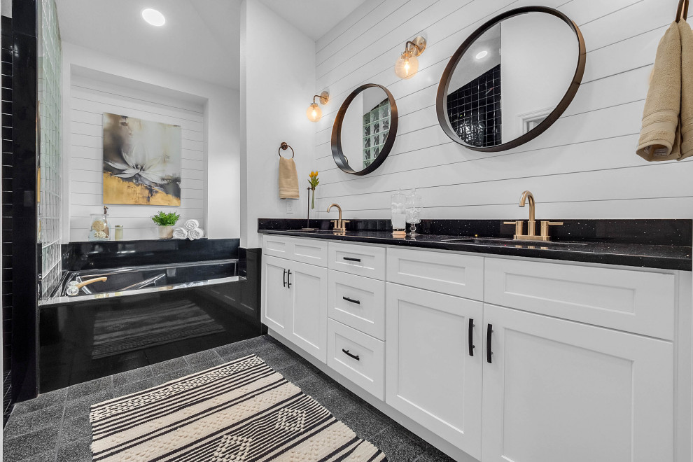Large classic ensuite bathroom in Orlando with shaker cabinets, white cabinets, a submerged bath, white walls, a submerged sink, grey floors, black worktops, double sinks, a built in vanity unit and tongue and groove walls.