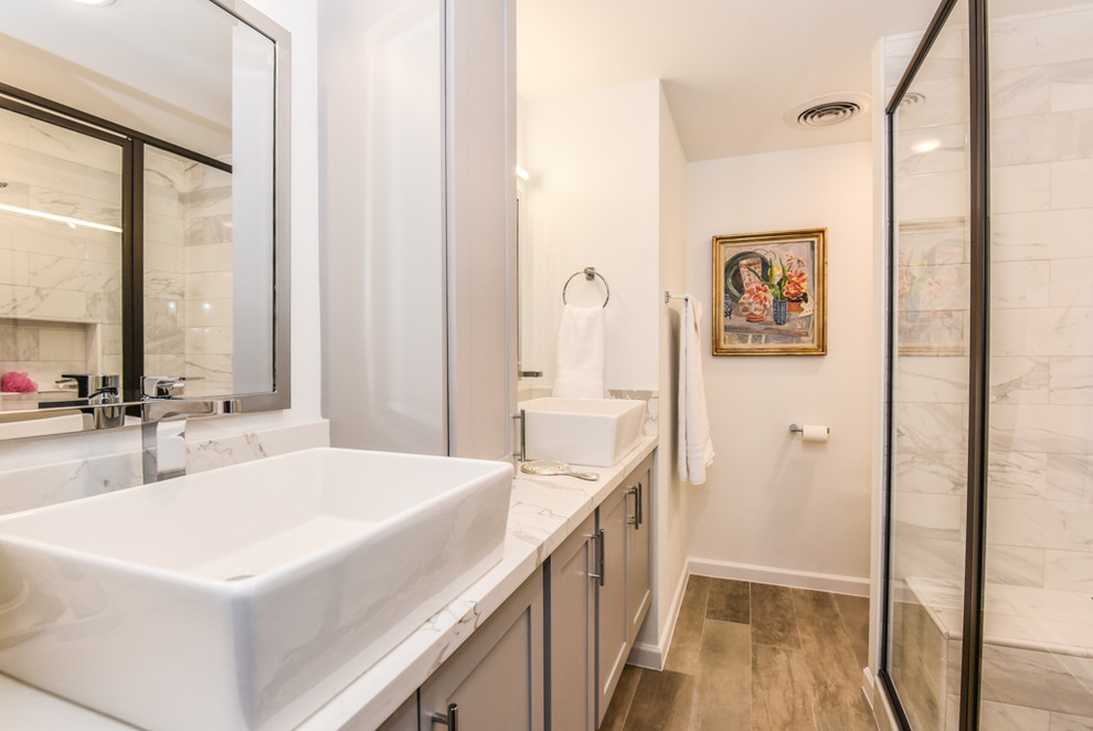 Mid-sized trendy master white tile and marble tile porcelain tile and beige floor walk-in shower photo in Houston with recessed-panel cabinets, white cabinets, white walls, a vessel sink, quartzite countertops and a hinged shower door