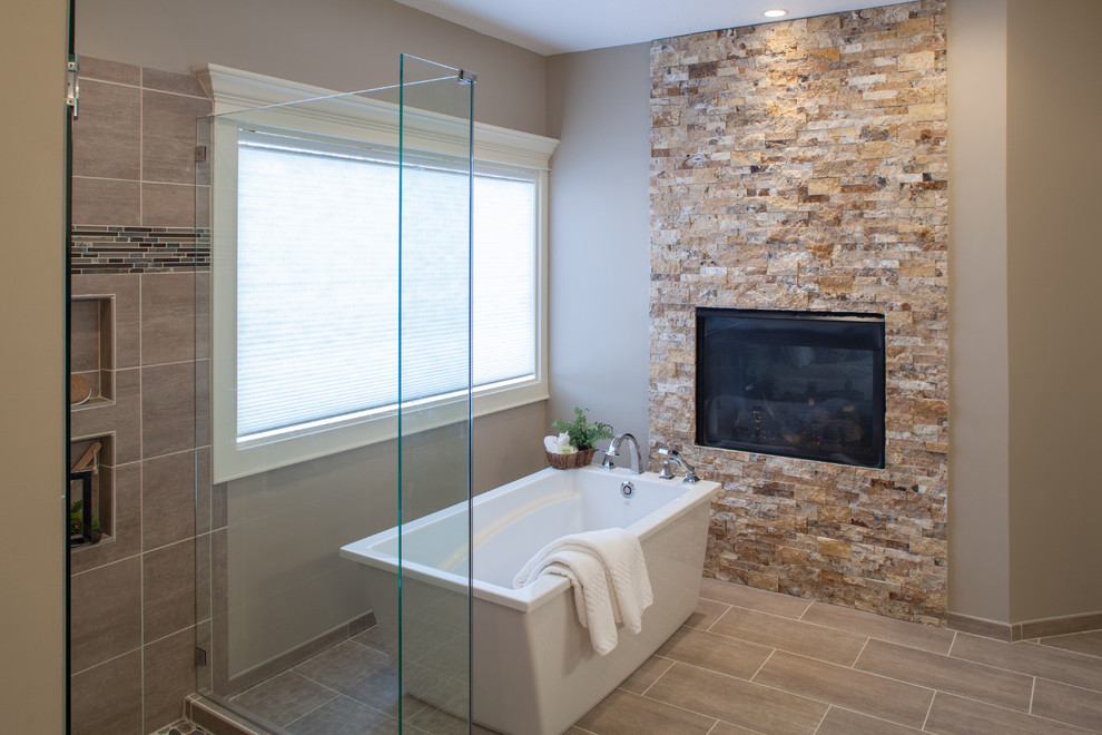 This is an example of a large traditional ensuite bathroom in Kansas City with recessed-panel cabinets, dark wood cabinets, a freestanding bath, a corner shower, grey walls, porcelain flooring, a submerged sink, granite worktops, beige floors and a hinged door.